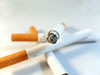 cigarettes - a photo of some cigarettes laying on table; one is lit