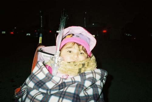 new years eve watching fireworks - Picture of girl bundled up in big flannel blanket with head peeking out in pink stroller in the cold