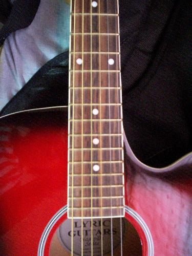 guitar - this is a close-up photo of my red acoustic guitar which i bought as a gift for myself last year. i named it after a character in one of favorite movies/books. you may call it aragorn.