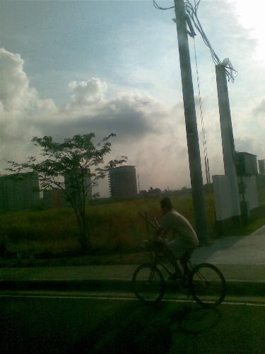 bicycle ride - i took this shot from the inside of a car with tinted windows that's why it's a bit dark. this is also what i call an accidental shot because the biker just appeared when all i was trying to capture is the field and the sunshine of that one sunday morning.
