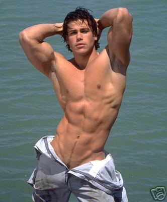 a muscular guy standing in the water shirtless wit - a muscular guy standing in the water shirtless with his pants pulled down to his waist holding his arms above his head
