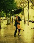 Couple - A happy moment in a couple's life. Perhaps, right after they've shared a kiss in the rain. They are dancing down the sidewalk of a usually busy street at sunset. As she's walking he firmly put its arm around her waist and pulls her in close. So that their eye to eye. Then he kisses her gently on the lips while she holds the umbrella.