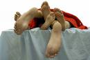 threesome - Three pair of feet in bed, suggesting a threesome. threesome - Three pair of feet in bed, suggesting a threesome.