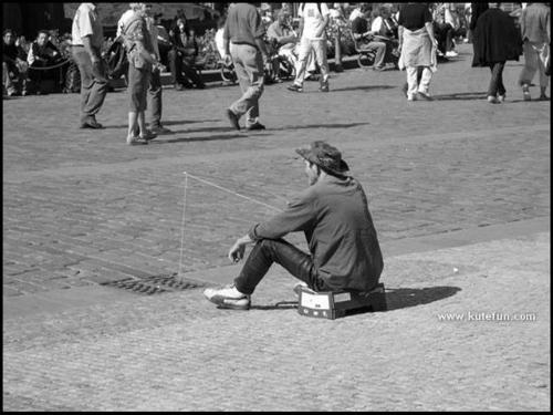 fishing on the road! - i dont know what he's doing exactly!!look at him he's fishing at the center of the road!! some people will do like this ,just for getting crowd's attention!!