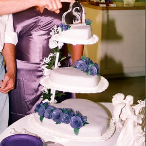 wedding cake - Triple floating hearts covered in violet fondant with dark purple fondant roses.