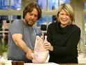 a girl can dream - Picture of Martha Stewart in a black sweatshirt next to a bearded man with semi-long hair and grey t-shirt holding up a raw chicken and stewart is laughing hysterically