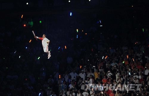 olympic - flying people are going to set fire the main torch.