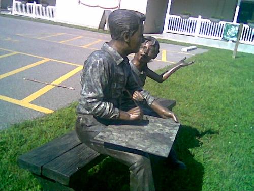 Statue of a man and young girl. - This statue shows a young man and girl and it looks like they are in conversation. This is placed by near the visitors center on the sidewalk. It looks really good.