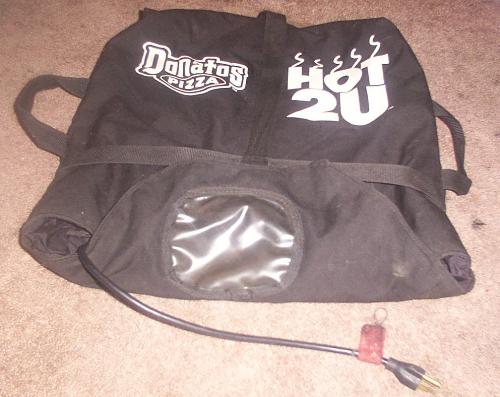 Pizza Delivery Bag - This is bag in which is used to deliver pizza. It is designed so that it conserves the heat of the pizza so it is not cold when it is delivered to the recipients. The bag is black with white writing,