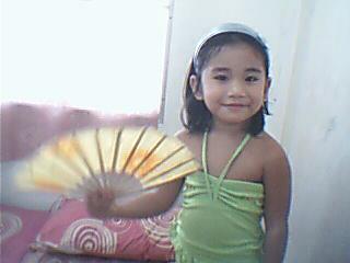 The Kid and the Fan - A great pose by a child who knows how. She wanted to joing the beauty contest.