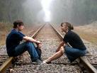 so much to talk about - two kids a girl and boy sitting on the train tracks deep in the woods talking