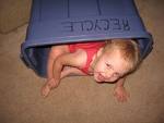 oops, did i teach him that? - Picture of a young boy crawled into a plastin bin with his head sticking out with huge smile