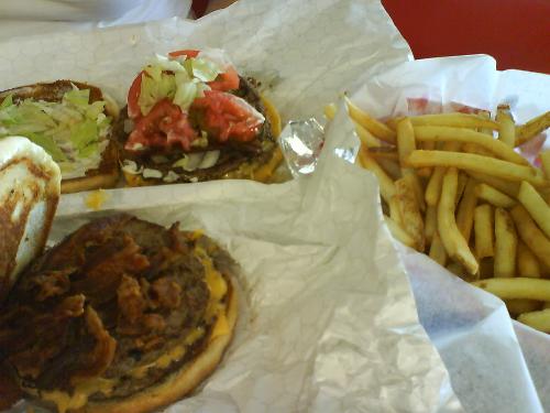 Hamburgers and fries - Two double bacon cheeseburgers and a basket of fries. We got all of this food for only ten dollars while traveling in west texas. The burger was very juicy and it was delicious. The fries were crispy and seasoned very well.
