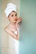 um... - A caucasian lady with towel wrapped on her head and towel around her peeking out of a shower
