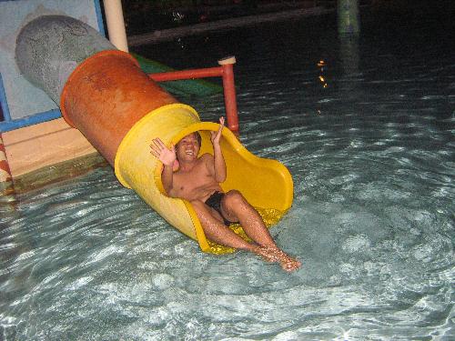 esmie's night swimming birthday party - wilme fooling around in the slide in the kiddie pool