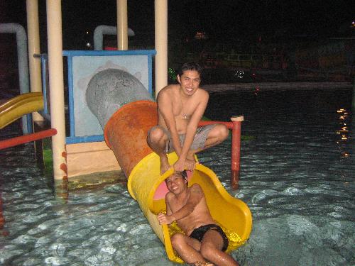esmie's night swimming birthday party - richard and wilme fooling around in the slide in the kiddie pool