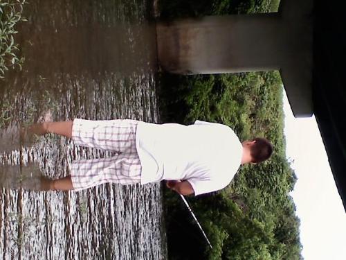 Sports - Fishing - Son wading in the river fishing.