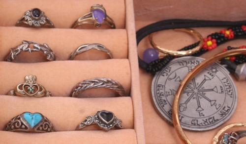Artistically Crafted Jewellery - Several artistically crafted rings, charms, pendants, and bracelets, in a jewellery box.