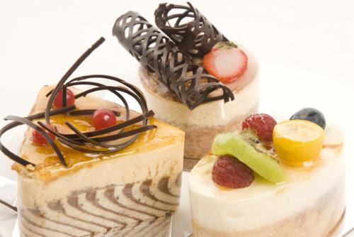 Cakes for desserts - Three slices of creatively decorated cakes, cut in three different shapes — triangular, circle and oval.