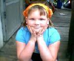 Lisa my lil sis ! - This is a photo of my little sister at my house sitting on steps smiling pretty at the camera, she is wearing a Handkerchief in her hair as a hair accessory.