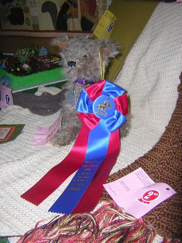 Sam the Judges Award Winner - This is Sam, the winner of the Judges Award at the California Mid State Fair in Paso Robles California. The Judges Award is next best to winning the Sweepstakes Award. I am aiming my sights at winning the sweepstakes award next year.  Sam is mohair fabric with ultra suede paws and ear linings. He also has imported shoe button eyes and a dog license from Hawaii. (I found the tag at a thrift shop here in California.) His head and hind legs are jointed. The pattern is from a wonderful Australian artist by the name of Lisa Pay.   I do design and make teddy bears, and have done so for the past 25 years. I love the freedom of being an artist and am so pleased that my creations make people so happy. I have 6 teddy bears on display at the Tokyo Teddy Bear Museum in Japan and have bears in homes all over the world. It is so awe inspiring and humbling to me to find people enjoy my designs so much. But when I started making my creations I decided that if I couldn't enjoy what I am doing I wouldn't do it. I did take 8 years off when my Mom passed away in 2000, although I did still make bears I just didn't have the heart to do many shows because of loosing my partner and my best friend.