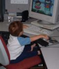 child sitting at computer - child sitting in front of computer playing games