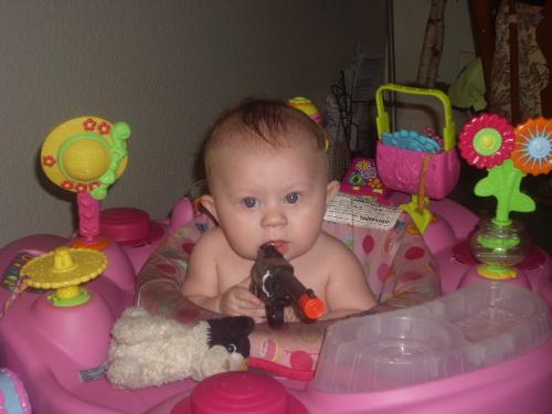 My daughter joins the NRA  - This is a picture of my 6 month old daughter holding her brothers toy gun. She sure looks like she knows what she is doing doesn't she?