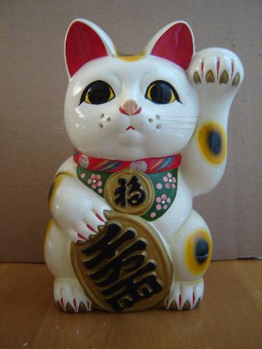 Making money - A ceramic cat figure called 'manekineko' in Japanese. Believed to bring fortune to businesses/households. The left paw is inviting in all the fortune to come to. Supposed to be placed facing the front door.