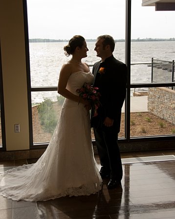 A profile of the happy couple - A photo of a newly married couple by the lake.