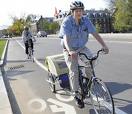 no problem - A guy in a helmet and riding a bike with bike trailer behind him