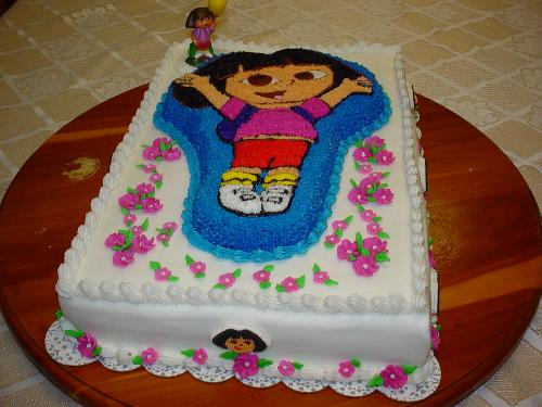 Dora Cake - Dora character cake on top of sheet cake. Flowers are royal icing.