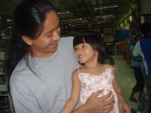 My husband and my baby girl janel - This is a picture of my husband and my daughter. They are so cute. We were at the grocery during this time waiting to pay for the items we bought. Just took a few snapshots while waiting.