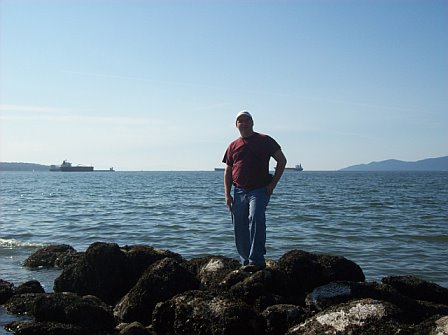 Me standing next to the Pacific Ocean. - This is a picture of me standing on some rocks next to the ocean.