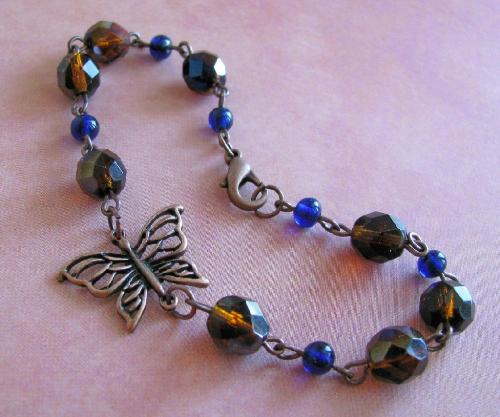Copper Butterfly Bracelet - This antiqued copper bracelet is 7 1/2' in length and finished with a lobster clasp. The beautiful copper filligree butterfly is approx 5/8'L x 3/4'W. The czech glass beads are a fire polished dark brown, with hints of deep blue. The accent beads are cobalt blue and pick up the blue in the czech beads. This is a simple, yet gorgeous bracelet!  Available in my Etsy.com shop.