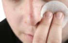 Good luck with acne -  A photo of a boy wiping face with acne.