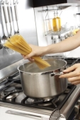 Putting pasta in the pot - Picture of someone putting pasta (spaghetti) into a pot.