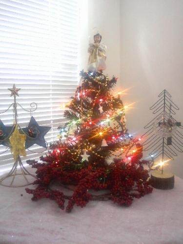 Small Christmas tree - Small Christmas tree, tabletop setting, with colored lights lit.