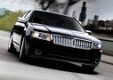 driving - a great, very expensive car driving down the road. The car is black.