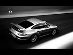 driving - a black car speeding down a dark, black road. The picture is clear but it also shows that the car is going ver fast.