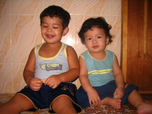 my two boys - sam and leaf in the kitchen. sitting on the floor.