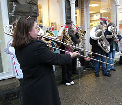 A brass band playing Christmas carols - A Christmas carols (also called noel) is a carol (song or hymn)whose lyrics are on the theme of Christmas.