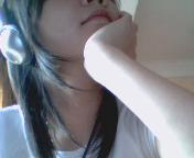 In half - An shy Asian girl listening through a headphone.