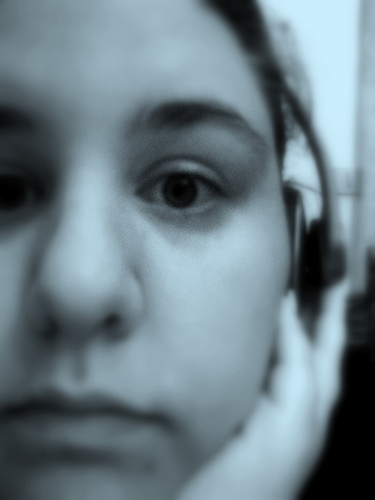 Bluer than blue - A depressing photo showing a sad girl listening to her music through a headphone.
