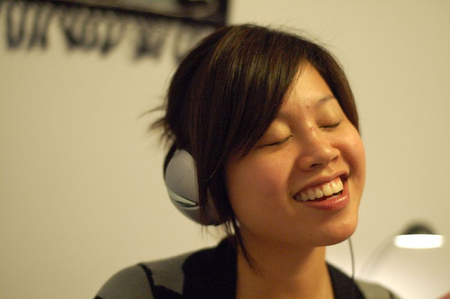 Asian Music - An Asian girl enjoying her time while listening to music through a headphone.