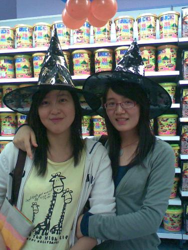 Like witches? - The two girls took this photo in the supermarket.When they put on these inteesting caps,they look funny,do they?HoHo~