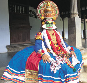 Kathakali - Costumes:  The headgear worn by the various characters in Kathakali are excellent specimen of intricate wood carving, an ancient speciality of the region. Even the shiny finishing with trinkets take hours of painstaking labour by expert craftsmen. Most of the ornaments donning each character are made in this fashion too.  Make-up:  The make-up, called Chutty in the bibliography of Kathakali, is also an art form in itself. The colourful faces are the results of hours of painstaking handiwork by expert artists. Their work is, by no means subordinate to portrait painting. The basic materials used for the make up are very crude items like raw amorphous Sulphur, Indigo, Rice paste, Lime, Coconut oil etc.  Music:  One of the major distinguishing features of Kathakali is the absence of oral communication. A considerable part of the script is in the form of lyrics, sung by vocalists. The only accompaniments are percussion instruments. Chenda(Drum played with sticks) Maddalam(Drum played with fingers), Chengila(Gong) and Ilathalam(Cymbals). The style of music traditionally accepted is Sopana, where the range is limited to one and half octaves. However, the influence of Karnataka Style of Classical Music has been irresistible, and the singers often take liberty with the style. It is not unusual that a Kathakali performance take the form of a Jugalbandi (Duet) of singing and acting.  Drumming especially of Chenda is the salient feature of Kathakali. Formerly considered an 'Asura Vadyam' meaning one that cannot go in harmony, Chena has become the most important feature. Artists are capable of producing a range of sounds varying from the gentle rattle of dry leaves in a breeze to reverberating thunder on Chenda.  Dance  Although dance is an important element in Kathakali, it is not the main feature. Pure dance sequences are limited to Kalasams, which punctuate acting segments. Female characters spontaneously breaking into 'Sari' and 'Kummi' dances can be seen in few dramas. The accent in Kathakali is more on the Thandava style of dancing than on Lasya style. Hence the movements are often explosive. Delicate movements are rare.  The communication among the characters and to the audience, is through an intricate language of hand gestures, used in combination with facial expression and body movements. Kathakali follows the language of Mudras.