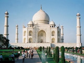 Thajmahal - Taj Mahal India - Located at Agra in Uttar Pradesh, the Taj Mahal is one of the most splendid masterpieces of architecture in the world. It was Emperor Shah Jehan who ordered the building of the Taj Mahal, in honor of his beloved wife, Arjumand Banu who was later known as Mumtaz Mahal, which means, the Distinguished of the Palace. One of the greatest monuments of India has been listed amongst the eight wonders of the world. This monument was built in the name of love and devotion. Do you know which is this grand Mughal monument situated in the heart of India? It is the Taj Mahal. It is considered to be one amongst the eight most majestic historical structures of the world. This white marble structure was the Mughal emperor, Shah Jahan’s, gift for his dead wife – Mumtaz Mahal. He loved his wife so much that he ordered for the best of artisans to create a design as there has never been, and something that cannot be replicated. Having rejected hundreds of designs he finally approved of this blue print. He is said to have personally monitored the construction of this building. The most expensive white marble was brought to Agra. The structure combines ingredients of Persian, India, Islamic and Turkish styles of architecture. It took twenty-two years to complete the construction of this architectural wonder. As per the records twenty thousand people were employed to work on this magnanimous project, which cost the Mughal emperor thirty-two million Rupees. According to the official documents, Ustad Isa was the master architect.  In 1983, this grand monument was announced by UNESCO to be one amongst the UNESCO World Heritage Sites. It was cited by the authorities as: 'The jewel of Muslim art in India and one of the universally admired masterpieces of the world's heritage.' And thereafter it attained global fame as one of the seven wonders of the world.   Between to two to four million tourists visit Agra, every year, to see this structure. World leaders ensure that visiting this global tourist spot is a part of their plan when visiting India. On her last visit to India, Lady Diana spent a long time in front of the Taj Mahal, simply admiring its grandeur. Taj Mahal History :  Mumtaz and Shah Jehan were married in 1612 A.D had 14 children together. The Empress Mumtaz used to accompany her husband in his military campaigns, and it was in Burhanpur in 1630, that she gave birth to her last child, after which she died. So great was the Shah Jahan's love for his wife Mumtaz, that he ordered the building of the most beautiful mausoleum on Earth for her, The Taj Mahal. As soon as construction work began in early 1630, sculptors, masons, craftsmen, and calligraphers were called from Persia, Ottoman Empire and Europe to work on construction of the Taj. The architectural complex of the Taj Mahal comprises of five main elements: the Darwaza or main gateway, the Bageecha or garden, the Masjid or mosque, the Naqqar Khana or rest house, and the Rauza or the Taj Mahal mausoleum.  The actual Tomb of Mumtaz is situated inside the Taj. The unique moghal style architecture combines elements & styles of Persian, Central Asian, and Islamic architecture. Most striking are the black and white chessboard marble floor, the four tall minarets (40 m high) at the corners of the structure, and the majestic grand dome in the middle.  On closer inspection, the lettering of the Holy Quran verses around the archways appear to be uniform. The lettering spacing and density has been customized to give this impression to the viewer. The impressive pietra dura artwork includes geometric elements & style, plants & flowers, which are common in Islamic architecture. The level of sophistication in artwork includes a 3 cm decorative element containing more than 50 inlaid gemstones.
