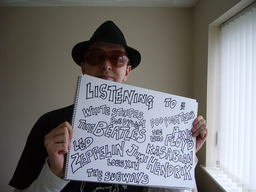 These are the artists I listen to - A man with sunglasses showing his favorite musicians that he usually listen to.