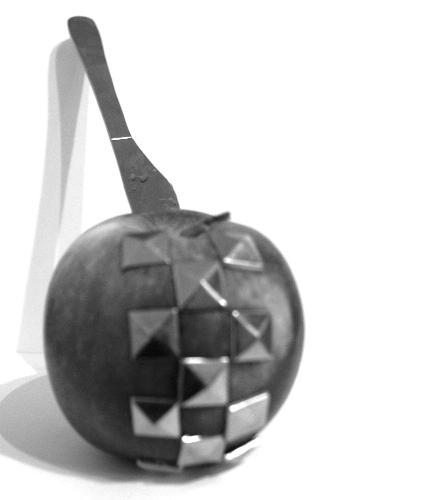 An apple with stud and a knife - This is a picture i took as a joke and i think it looks so cool. its an apple with studs from a belt stuck in it, and i knife aswell. i put it in black and white cos that makes it look much cooler