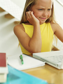 in front of the computer - a girl looks embarrassed in front of her computer in front of the computer - a girl looks embarrassed in front of her computer